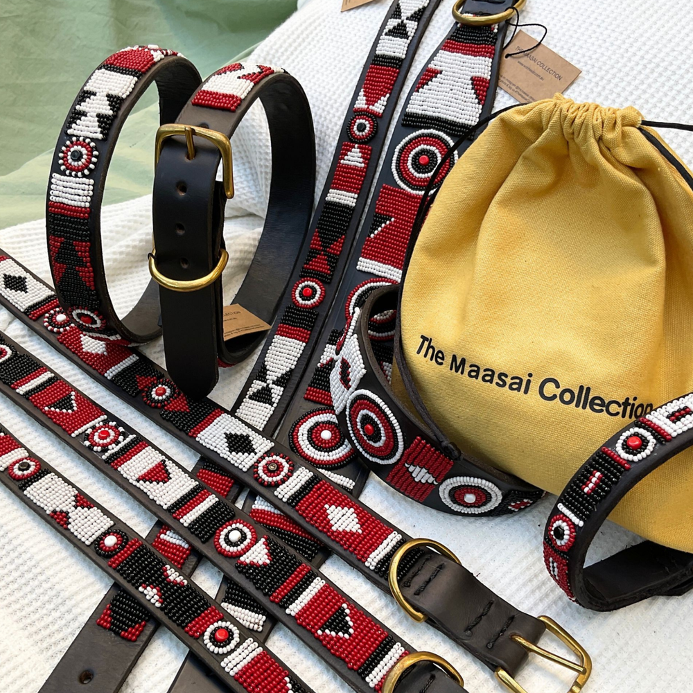group photo of multiple different sizes and widths of red white and black handmade beaded leather collars from The Maasai Collection in Pride design