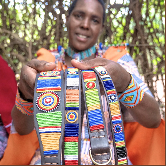 Maasai Mara Mama in traditional clothing showcasing her hand made dog collars for The Maasai Collection  in the Sundance design